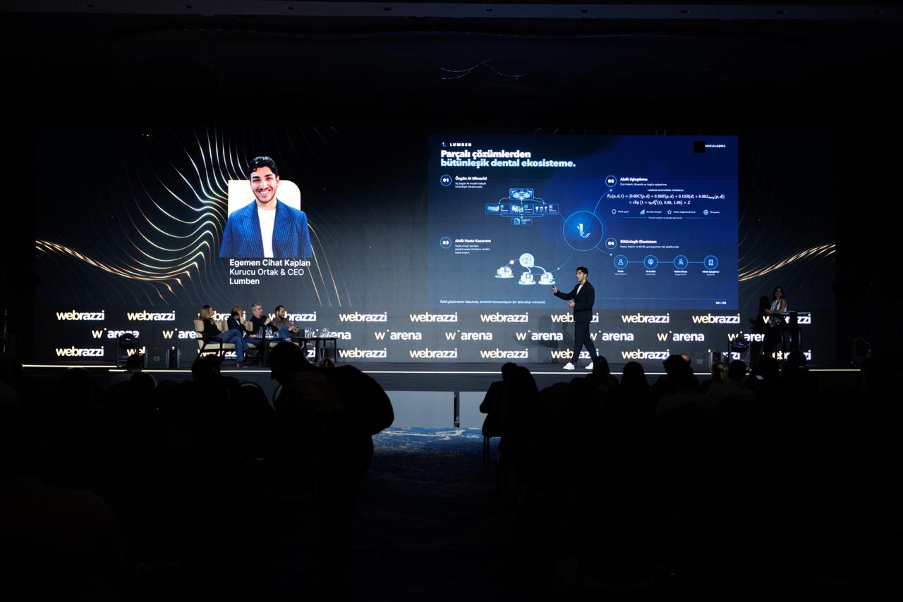 Egemen Cihat Kaplan, Lumben's co-founder and CEO, presenting on the Webrazzi Arena 2026 stage in front of a large screen showing a Lumben slide